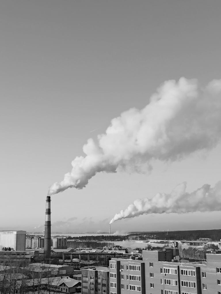 Black and white photo of smokestacks emitting smoke in Berdsk, Russia, showcasing urban industry.