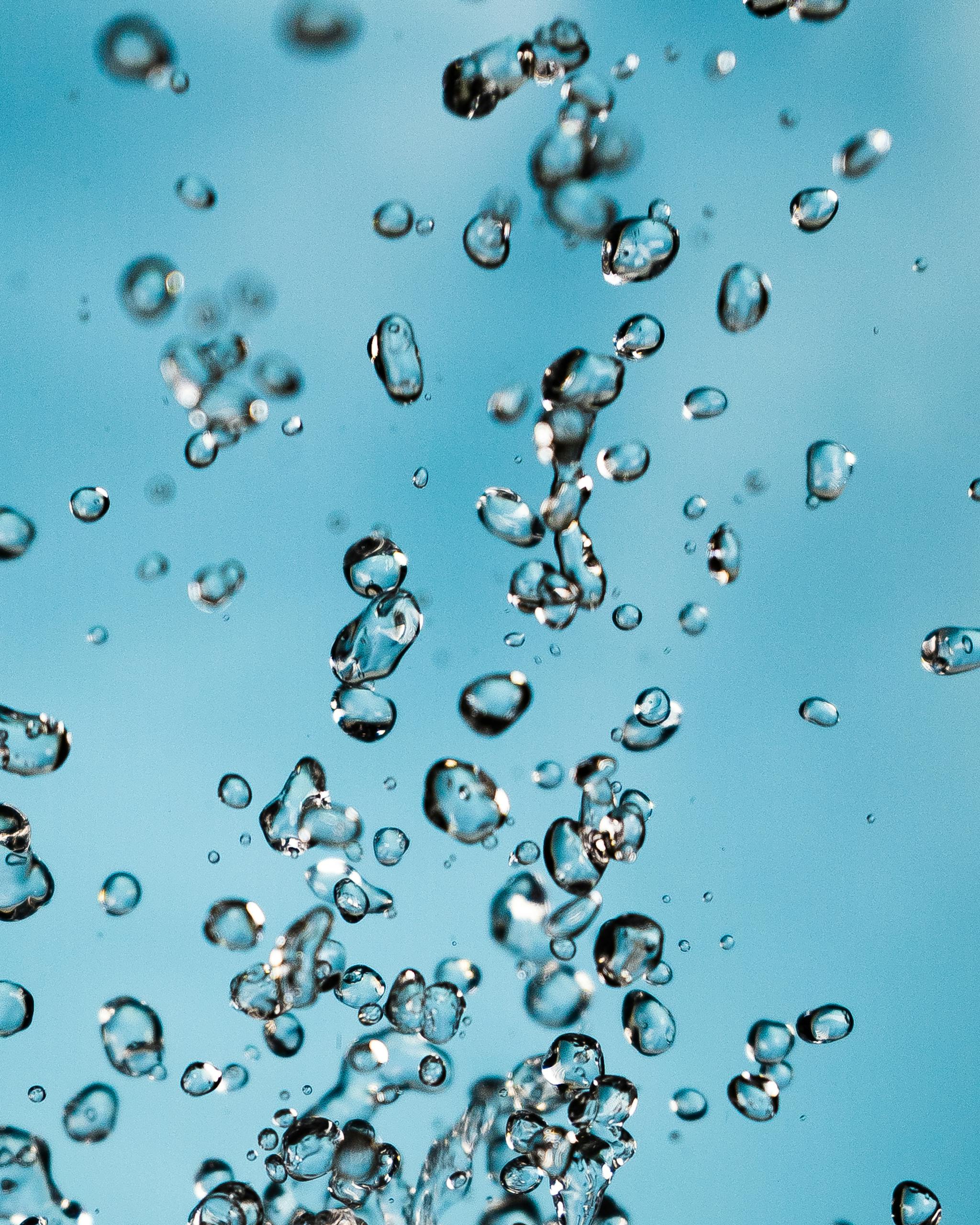 Vibrant image capturing water droplets suspended against a bright blue sky background.